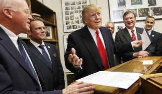 In this Nov. 4, 2015, file photo, New Hampshire Secretary of State Bill Gardner, left, watches at left as Republican presidential candidate Donald Trump reacts after filling out his filing papers to be on the nation&#39;s earliest presidential primary ballot at the Secretary of State&#39;s office in Concord, N.H. Gardner has been defending the request for detailed voter information from the Trump administration&#39;s commission on voter fraud. Gardner, a member of the commission, plans to provide publicly-accessible information, though critics argue state law allows the entire database to be provided only to political parties, political committees and candidates. Gardner is facing criticism for his decision, including from residents who inundated his office with calls. (AP Photo/Jim Cole, File) 