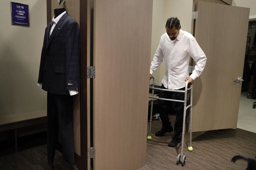Jamie Nieto, a two-time Olympic high jumper who is recovering from a spinal cord injury, uses his walker as he steps out of a fitting room while getting his tuxedo fitted ahead of his July wedding, Wednesday, May 31, 2017, in Pasadena, Calif. Nieto was paralyzed last year when he celebrated by doing his trademark backflip during a training session. "My short-term goal is to walk at our wedding. That's what I'm working towards," said Nieto. (AP Photo/Jae C. Hong)
