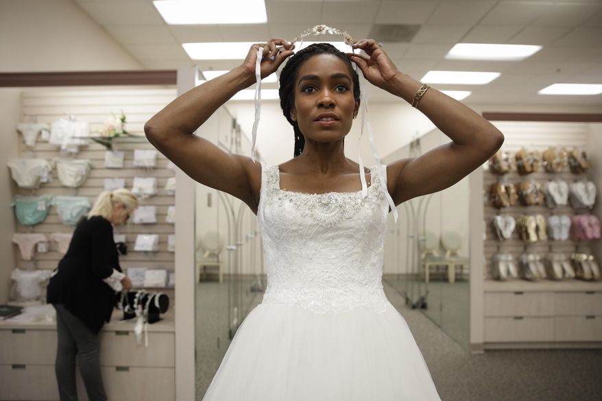 Shevon Stoddart, a 34-year-old Jamaican hurdler, tries on a tiara while getting her wedding dress fitted ahead of her July wedding with two-time Olympic high jumper Jamie Nieto, who is recovering from a spinal cord injury after a mistimed backflip, Tuesday, June 6, 2017, in Burbank, Calif. "The wedding will be an amazing day for us, and our family and friends and supporters who've helped us get through this," said Stoddart. (AP Photo/Jae C. Hong)