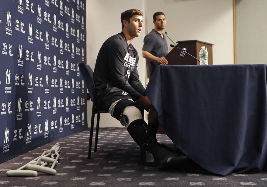 New York Yankees outfielder Dustin Fowler, left, speaks to the media during a press conference at Yankee Stadium in New York, Wednesday, July 5, 2017. Fowler ruptured his right patellar tendon last Thursday after crashing into the outfield wall in the first inning of his major league debut in Chicago.  (AP Photo/Kathy Willens)