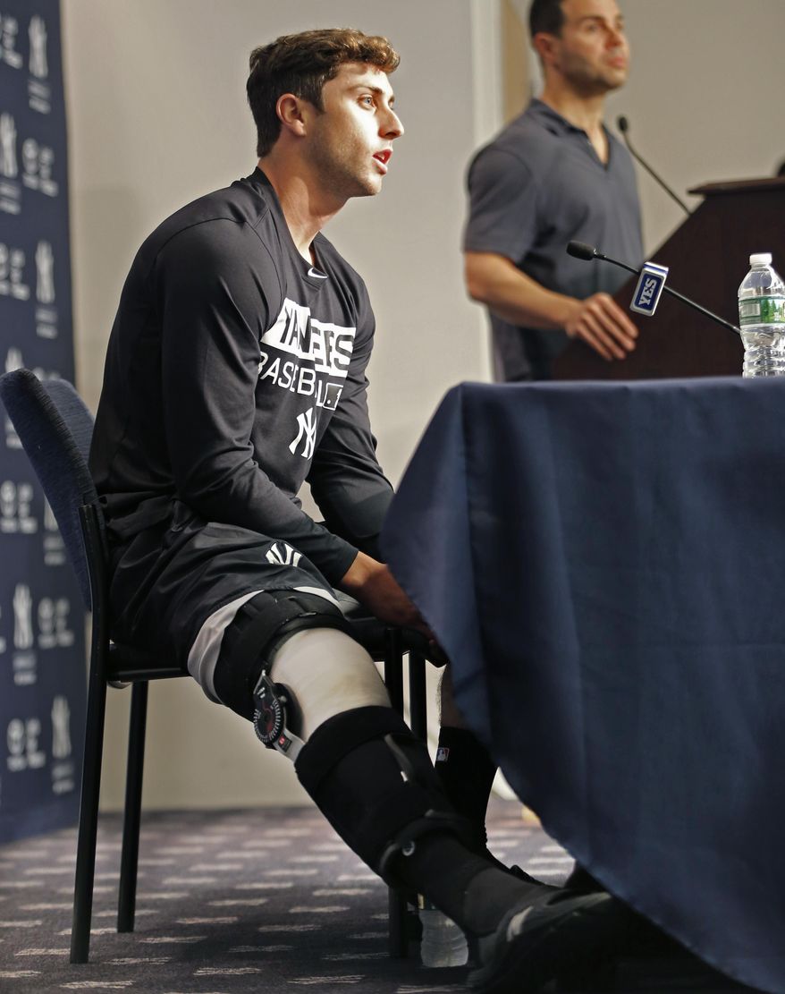 New York Yankees outfielder Dustin Fowler, left, speaks to the media during a press conference in New York, Wednesday, July 5, 2017. Fowler ruptured his right patellar tendon last Thursday after crashing into the outfield wall in the first inning of his major league debut in Chicago.  (AP Photo/Kathy Willens)