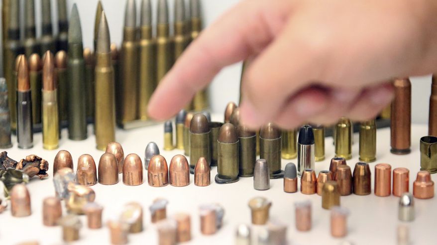 Justin Bechaver, a forensic scientist with the Department of Public Safety, points to a bullet collection at the Utah state crime lab in Taylorsville, Utah. Kidnapping victim Elizabeth Smart and Sen. Orrin Hatch, R-Utah, toured the new state crime lab Thursday. (AP Photo/Rick Bowmer)