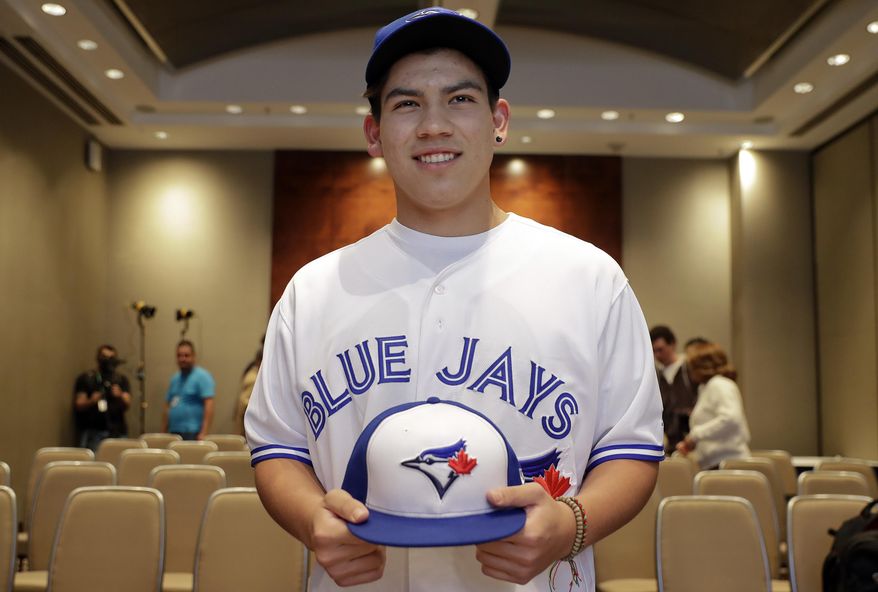 Baseball player Eric Pardinho poses for a picture wearing his new team uniform, after a signing contract in Sao Paulo, Brazil, Thursday, July 6, 2017. Brazil's 16-year-old baseball wonder signed with Toronto Blue Jays. He will spend some time in the Dominican Republic in his initial minor league steps towards Major League Baseball. (AP Photo/Andre Penner)