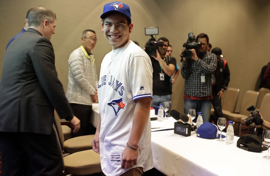 Baseball player Eric Pardinho poses for a picture wearing his new team uniform, after a signing contract in Sao Paulo, Brazil, Thursday, July 6, 2017. Brazil's 16-year-old baseball wonder signed with Toronto Blue Jays. He will spend some time in the Dominican Republic in his initial minor league steps towards Major League Baseball. (AP Photo/Andre Penner)