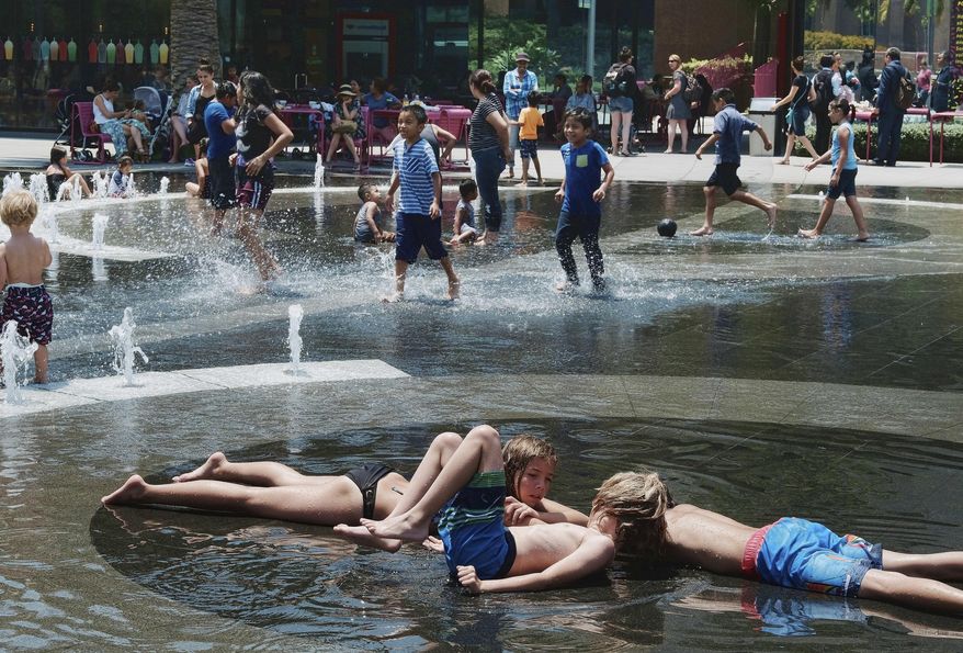 Children out of school for the summer take advantage of the Grand Park fountain in downtown Los Angeles on Wednesday, July 5, 2017. Forecasters say a new heat wave is setting in across the interior of Southern California, and the southern Sierra Nevada is facing a period of elevated fire danger. The National Weather Service says the heat is coming from high pressure building over the desert Southwest that will expand westward. (AP Photo/Richard Vogel)