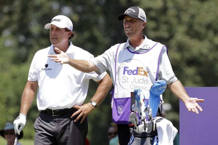 FILE - In this June 11, 2015, file photo, Phil Mickelson, left, talks with his caddie Jim Mackay on the eighth tee during the first round of the St. Jude Classic golf tournament in Memphis, Tenn. The longtime caddie for Phil Mickelson is going to work for NBC and Golf Channel for the rest of the year. Jim "Bones" Mackay will still be walking golf courses, but with a microphone instead of a 40-pound golf bag. Mackay was the only caddie Mickelson had in his 25-year career. They decided two weeks ago to part ways. (AP Photo/Mark Humphrey, File)