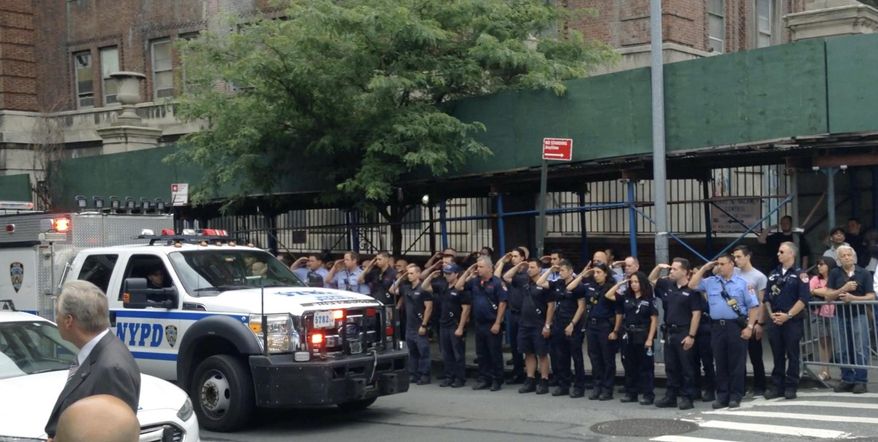 In this image taken from video, New York City Police and firefighters salute as the motorcade with the body of fallen NYPD officer Miosotis Familia leaves Bellevue Hospital in New York enroute to the funeral home, Thursday, July 6, 2017, in New York. Familia was shot and killed while on duty in the early hours of July 6 as she wrote in her notebook inside an NYPD Mobile Command Vehicle. (AP Photo/Robert Weisenfeld)