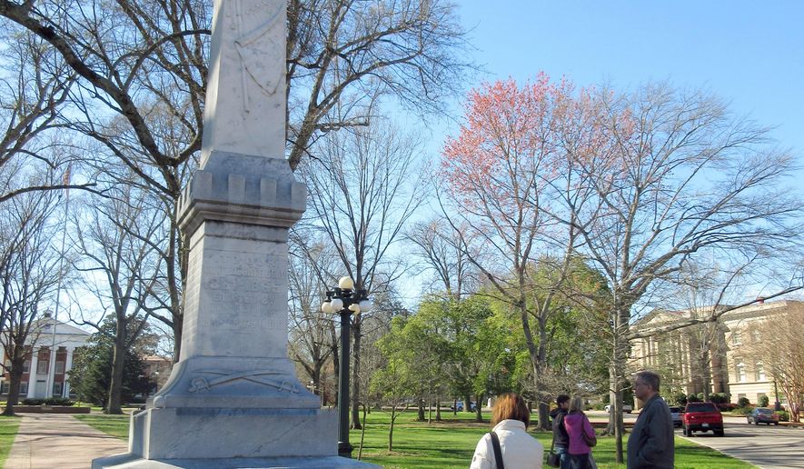 FILE- This March 12, 2017, file photo shows a statue of a Confederate soldier on the campus of the University of Mississippi in Oxford, Miss. The university announced Thursday, July 6, that it will post signs acknowledging that slaves built some structures on the main campus founded before the Civil War. The administration has already added a plaque to provide information about slavery and the Civil War to the Confederate soldier statue on campus. (AP Photo/Beth J. Harpaz, File)
