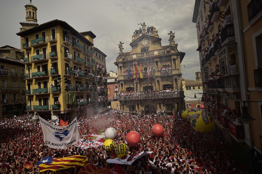 People celebrate during the launch of the 'Chupinazo' rocket, to celebrate the official opening of the 2017 San Fermin Fiestas, in Pamplona, northern Spain, Thursday, July 6, 2017. Revelers from around the world kick off the festival with a messy party in the Pamplona town square, one day before the first of eight days of the running of the bulls. (AP Photo/Alvaro Barrientos)