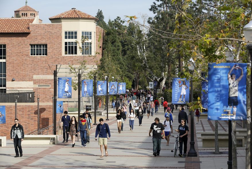 In this Feb. 26, 2015, file photo, students walk on the UCLA campus in Los Angeles. The University of California says it has offered admission to nearly 70,000 California undergraduates, a slight dip from last year's historic high. Preliminary figures released Thursday, July 6, 2017, show that a total of 106,011 students, including nonresidents, were accepted as freshmen to one of the public system's nine undergraduate campuses. (AP Photo/Damian Dovarganes, File)