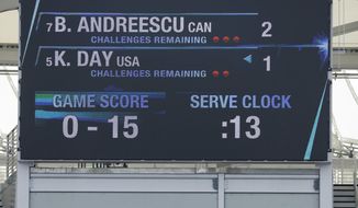 FILE - In this Sept. 10 2016, file photo, fans watch a junior girls semifinal match as the serve clock winds down on the scoreboard above during the U.S. Open tennis tournament in New York. The U.S. Open will experiment during its qualifying rounds this year with scoreboard clocks to limit how much time elapses between points and how long pre-match warmups or mid-match clothing changes can last. (AP Photo/Darron Cummings, File)