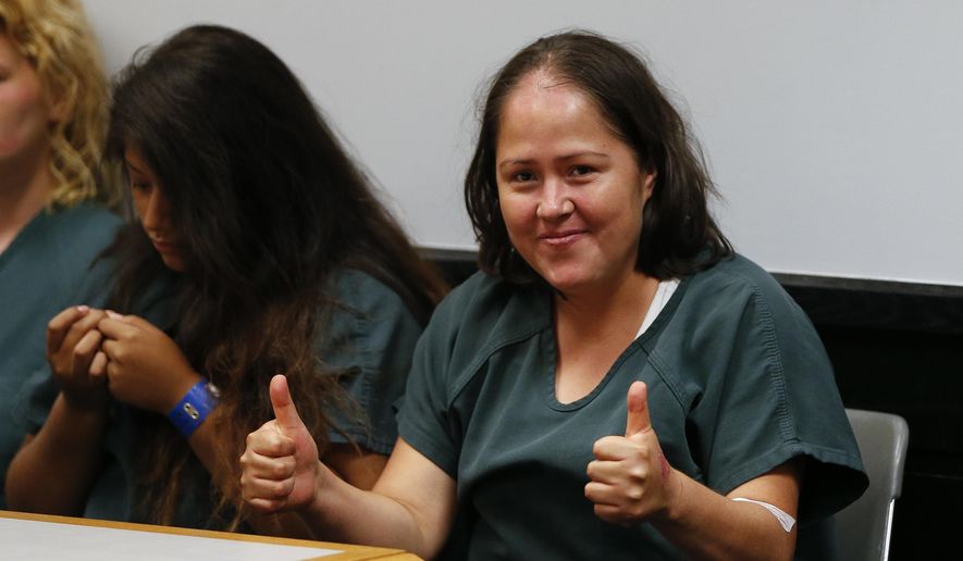 Isabel Martinez gestures towards news cameras during her first court appearance Friday, July 7, 2017, in Lawrenceville , Ga. Martinez is charged with killing four of her children and their father. (AP Photo/John Bazemore)