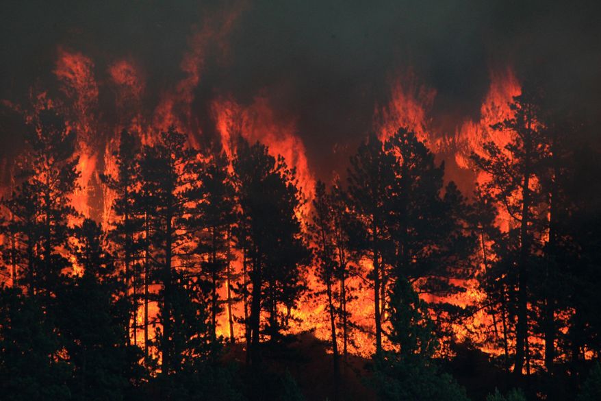 In this Thursday, July 6, 2017 photo, a wildfire burns near the historic mining town of Landusky, south of the Fort Belknap Indian Reservation in north-central Montana. Officials ordered about 30 residents to evacuate after winds shifted and the wildfire moved to within a mile of the historic mining town. (Meg Oliphant/The Billings Gazette via AP)