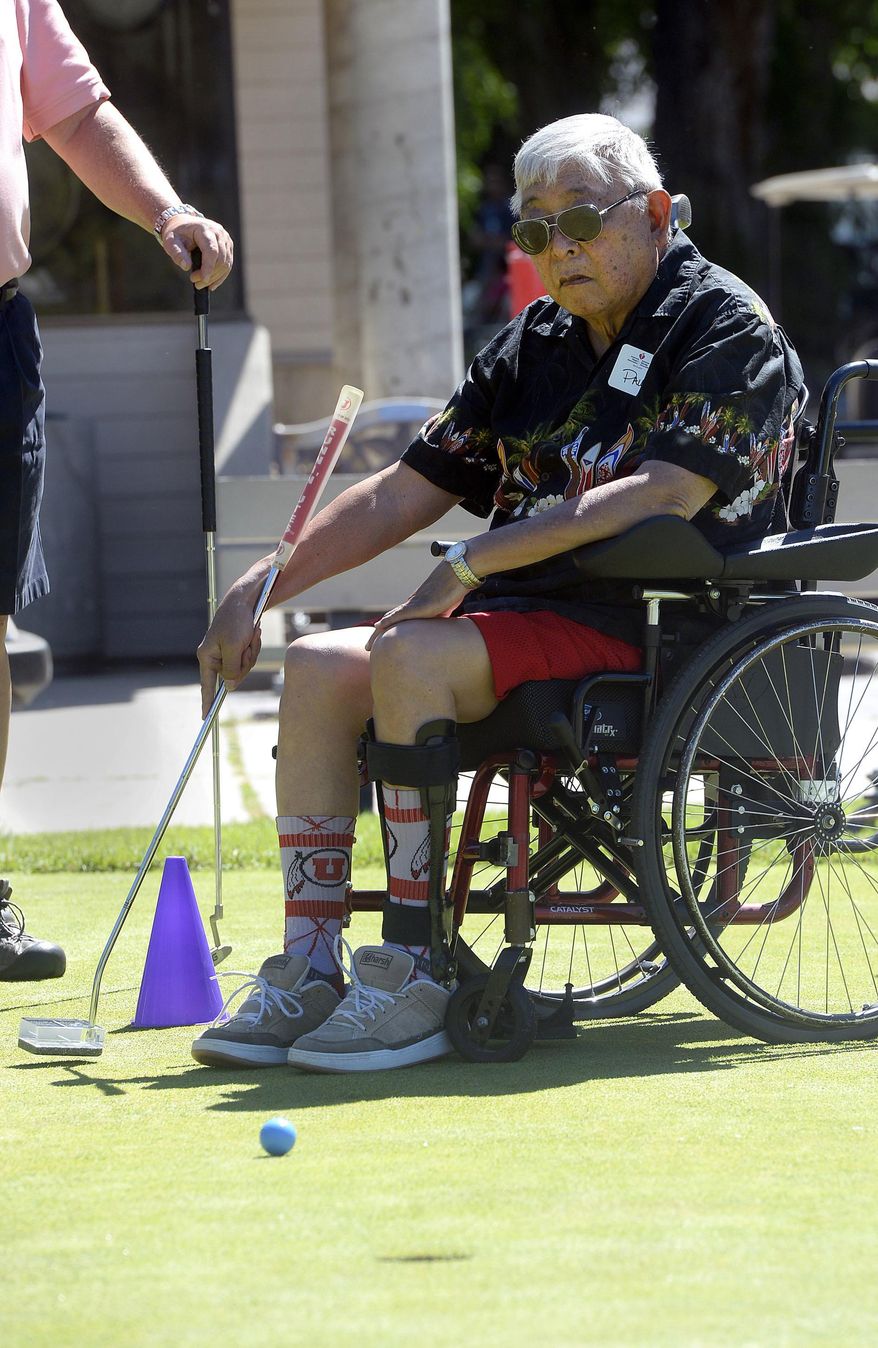 In a Friday, June 16, 2017 photo, Paul Shino, who had a stroke eight years ago, makes a one-handed putt at Nibley Park Golf Course in Salt Lake City, Utah. He was among stroke survivors, in all stages of recovery, playing golf at the Saving Strokes Golf Clinic. (Al Hartmann/The Salt Lake Tribune via AP)