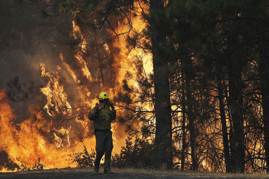 FILE - In this Aug. 25, 2013 file photo, firefighter A.J. Tevis watches the flames of the Rim Fire near Yosemite National Park, Calif. California&#39;s emergency services director says the federal government has failed to reimburse $18 million for fighting fires on federal lands in the state. Mark Ghilarducci said in a sharply worded letter to the U.S. Forest Service chief this week that the federal agency had ignored its financial responsibility and raised the possibility the state might stop responding to fires in national forests, Friday, July 7, 2017. (AP Photo/Jae C. Hong, File)