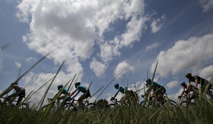 The pack with team Astana riders, in blue, passes during the seventh stage of the Tour de France cycling race over 213.5 kilometers (132.7 miles) with start in Troyes and finish in Nuits-Saint-Georges, France, Friday, July 7, 2017. (AP Photo/Christophe Ena)