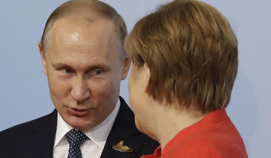 Russian President Vladimir Putin, left, is welcomed by German Chancellor Angela Merkel on the first day of the G-20 summit in Hamburg, northern Germany, Friday, July 7, 2017. The leaders of the group of 20 meet July 7 and 8. (AP Photo/Michael Sohn)