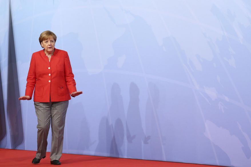 German chancellor Angela Merkel waits to welcome guests at the start of the G-20 summit in Hamburg, Germany, Friday, July 7, 2017. (Christian Charisius/dpa via AP)