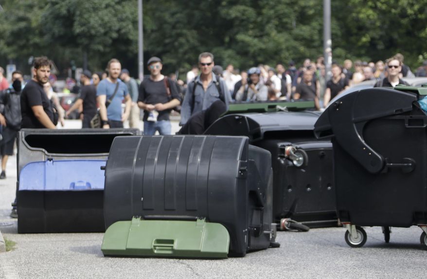 Demonstrators turn waste bins on the first day of the G-20 summit in Hamburg, northern Germany, Friday, July 7, 2017. The leaders of the group of 20 meet July 7 and 8. (AP Photo/Matthias Schrader)