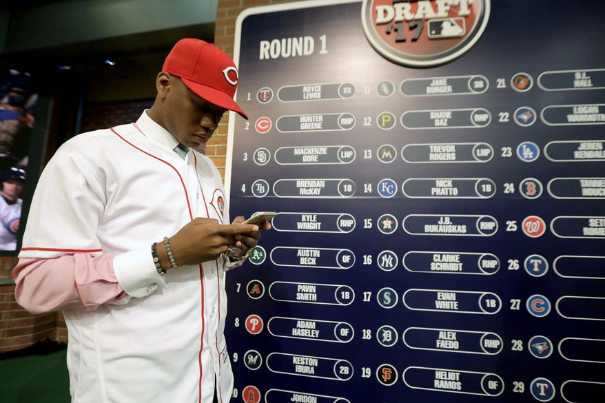 FILE - In this June 12, 2017, file photo, Hunter Greene, a pitcher and shortstop from Notre Dame High School in Sherman Oaks, Calif., stands near the draft board after being selected No. 2 by the Cincinnati Reds in the first round of the Major League Baseball draft in Secaucus, N.J. Greene has agreed to a minor league contract with a $7.23 million signing bonus–the highest since constraints on draft spending began in 2012. (AP Photo/Julio Cortez, File)