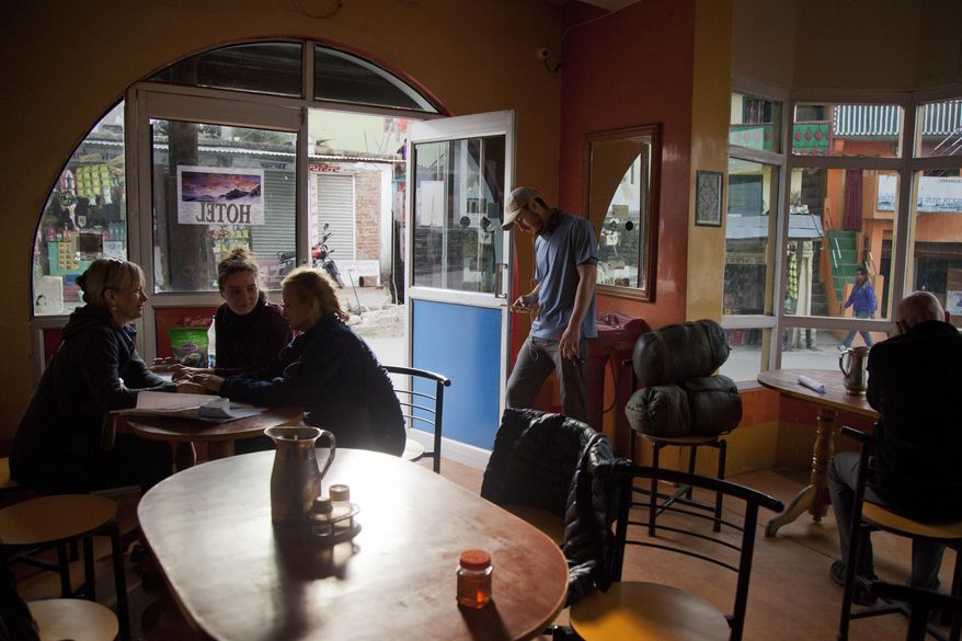 In this March 25, 2017 photo, Elizabeth Brenner, left, talks to her sister Sara Mickman, and her niece Sophia, at a restaurant in the town of Munsiyari in the mountainous state of Uttarakhand, India. Brenner was discussing her journey a day before they set off on a hike through narrow, rocky trails that lead to the spot where Brenner's son died in 2011. They were accompanied by Elizabeth's partner Barry Knight, right, and Knight's son Max, second right. (AP Photo/Rishabh R. Jain)