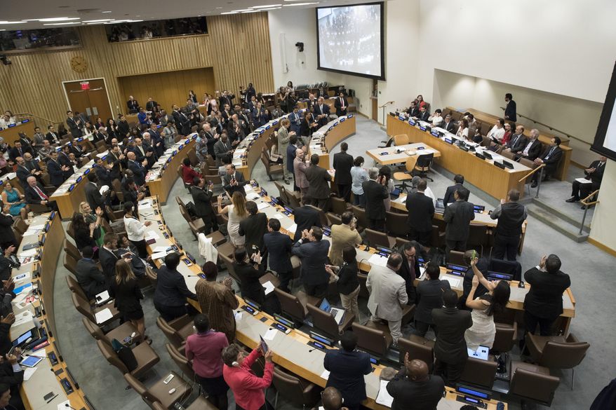 Delegates give a standing ovation after a vote by the conference to adopt a legally binding instrument to prohibit nuclear weapons, leading towards their total elimination, Friday, July 7, 2017 at United Nations headquarters. More than 120 countries have approved the first-ever treaty banning nuclear weapons at a U.N. meeting boycotted by all nuclear-armed nations. Friday's vote was 122 countries in favor with the Netherlands opposed and Singapore abstaining.(AP Photo/Mary Altaffer)