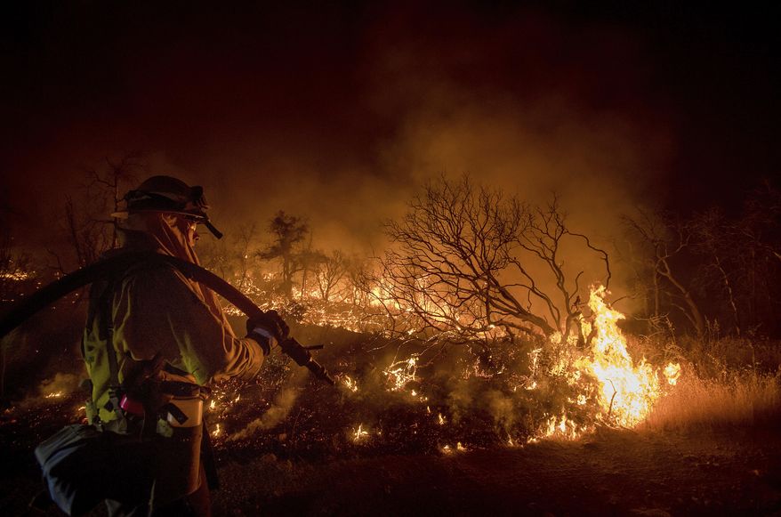 Firefighter Kern Kunst battles the Wall fire near Oroville, Calif., on Saturday, July 8, 2017. According to CalFire, the blaze has scorched 1,000 acres and destroyed 10 homes. (AP Photo/Noah Berger)
