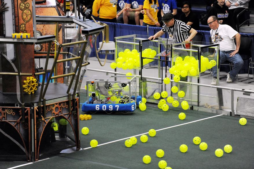 The Botcats team of Brethren, Michigan, released balls from containers during the FIRST Robotics District Competition in March. Teams of youths from nearly 160 nations have spent weeks building remote-controlled robots designed to maneuver through a variety of obstacles and compete to finish specific goals. (Associated Press)