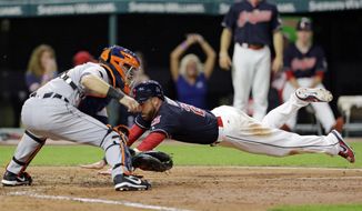 Cleveland Indians&#39; Jason Kipnis dives into home plate to score as Detroit Tigers catcher Alex Avila waits for the ball during the seventh inning of a baseball game, Friday, July 7, 2017, in Cleveland. (AP Photo/Tony Dejak)