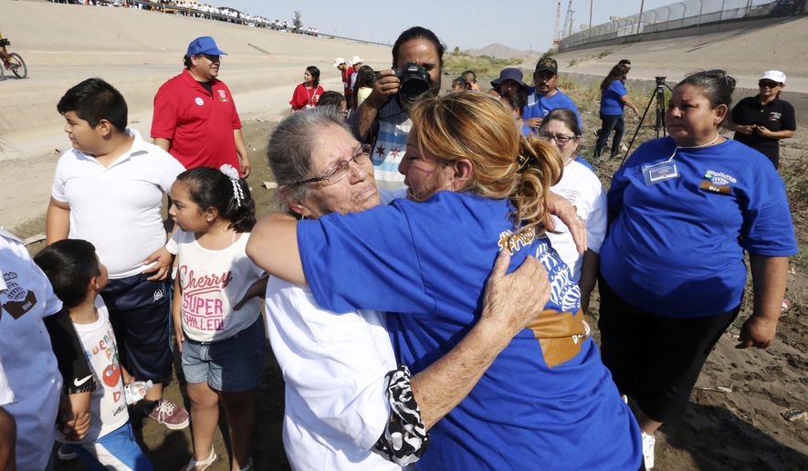 In this Saturday, June 24, 2017 photo, Erendira Fraire, right, rushes over to greet her mother, Esperanza Mata Lara whom she had not seen in 21 years during a brief meeting in the Rio Grande riverbed as part of the "Hugs Not Walls" family reunification event on the U.S-Mexico border. Fraire traveled from Chicago while her mother traveled from Gomez Palacio, Durango, Mexico for the four-minute encounter. (Rudy Gutierrez/The El Paso Times via AP)