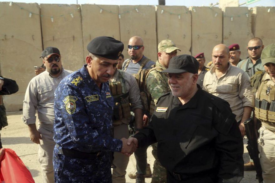 Iraq&#39;s Prime Minister Haider al-Abadi, center right, shakes hands with Lieutenant General Raid Shaker Jawlat, center left, the commander of Iraqi federal police upon his arrival in Mosul, Iraq, Sunday, July 9, 2017. Backed by the U.S.-led coalition, Iraq launched the operation to retake Mosul from Islamic State militants in October. (Iraqi Federal Police Press Office via AP)