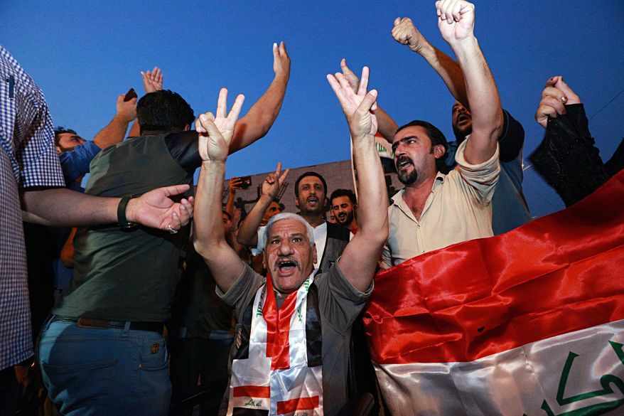 Iraqis celebrate in Tahrir square while holding national flags as they wait for the final announcement of the defeat of the Islamic state militants, in Baghdad, Iraq, Sunday, July 9, 2017. Backed by the U.S.-led coalition, Iraq launched the operation to retake Mosul from Islamic State militants in October. (AP Photo/Hadi Mizban)