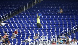 In this Tuesday, June 27, 2017, photo, a vendor walks through a section of mostly empty seats during the first inning of a baseball game between the Miami Marlins and the New York Mets at Marlins Park stadium in Miami. As the All-Star Game comes to Florida for the first time, the Marlins and Tampa Bay Rays continue their perennial struggles with attendance, raising the question: Does major league baseball belong in the state? (AP Photo/Wilfredo Lee)