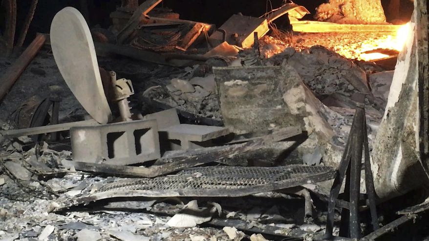 This photo provided by KEYT-TV shows a warped satellite dish in the ruins of a structure at Camp Whittier east of Cachuma Lake after a wildfire in Santa Barbara County, Calif., Sunday, July 9, 2017. Wildfires barreled across the baking landscape of the western U.S. and Canada, destroying a smattering of homes, forcing thousands to flee and temporarily trapping children and counselors at a California campground. Southern California crews hope slightly cooler temperatures and diminishing winds will help in the battle Sunday. (John Palminteri/KEYT-TV via AP)