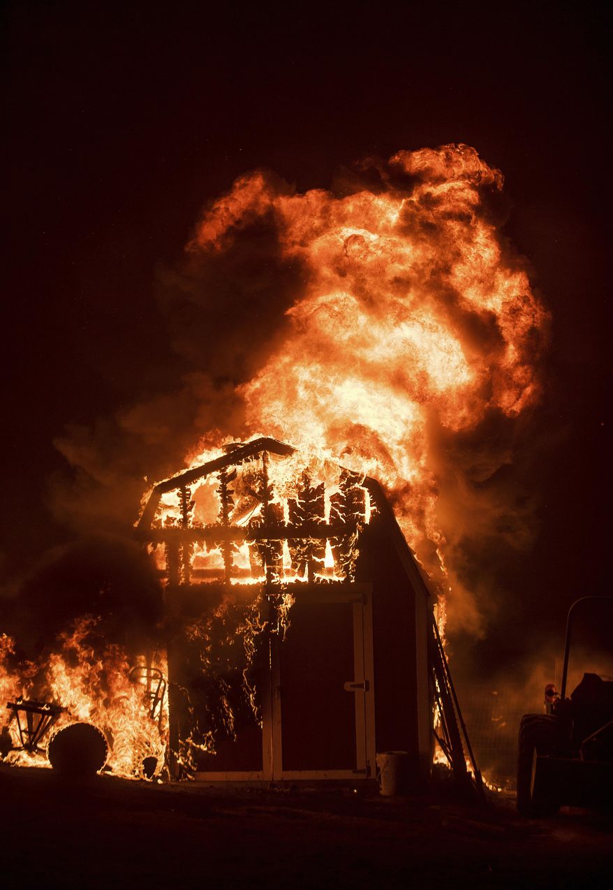 Flames from a wildfire consume a shed near Oroville, Calif., on Sunday, July 9, 2017. Evening winds drove the fire through several neighborhoods leveling homes in its path. (AP Photo/Noah Berger)
