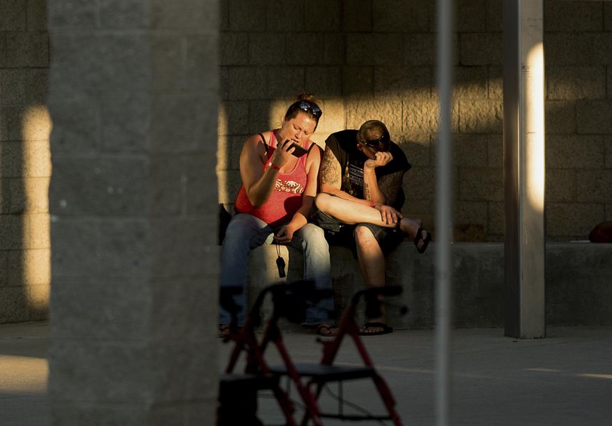 Josh Cornelison and Sharon Reitan rest outside an evacuation shelter for people affected by a wildfire on Sunday, July 9, 2017, in Oroville, Calif. The couple lost their home as the Wall tore through a mountain community Friday. (AP Photo/Noah Berger)