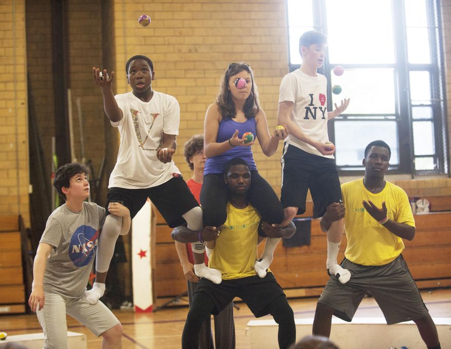 Duel Thompson, top left, juggles during a training session with Trenton Circus Squad, Monday, July 10, 2017. The circus is coming to Camden and training kids in a two-week camp: Trenton Circus Squad makes its first trip to the city, working with kids ages 12-18 as part of a two-week pilot program and hoping to establish a year-round presence. (Jose F. Moreno/Camden Courier-Post via AP)