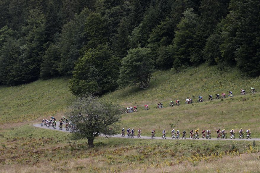 The pack with Britain's Chris Froome, wearing the overall leader's yellow jersey, speeds downhill during the ninth stage of the Tour de France cycling race over 181.5 kilometers (112.8 miles) with start in Nantua and finish in Chambery, France, Sunday, July 9, 2017. (AP Photo/Christophe Ena)