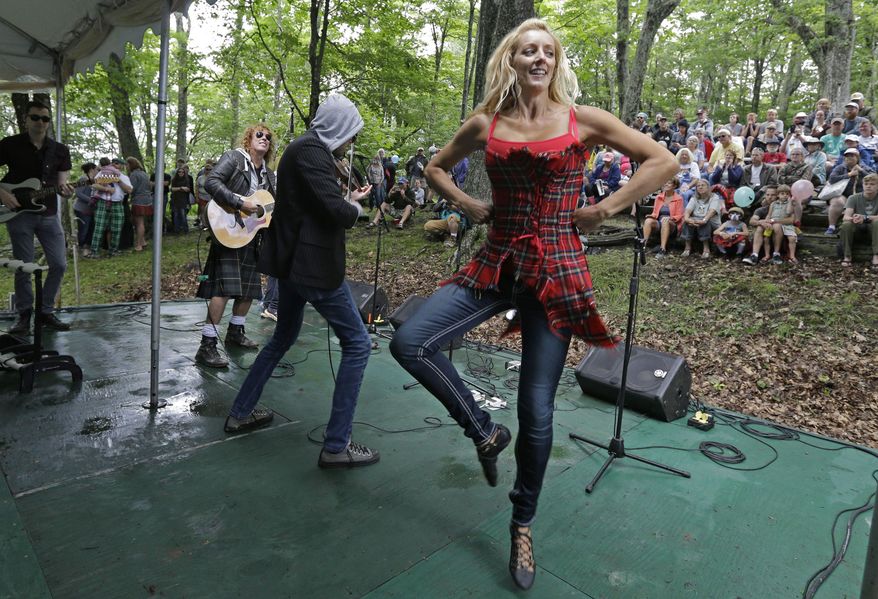 A woman dances as the band Seven Nations performs for the crowd during the 62nd Annual Grandfather Mountain Highland Games at Grandfather Mountain in Linville, N.C., Friday, July 7, 2017. Spectators watched demonstrations of sheep herding, highland dancing and listened to different bands and solo musicians perform among the large rocks and trees. (AP Photo/Chuck Burton)