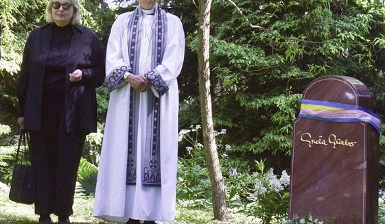 FILE - In this June 17, 1999 file photo, Gray Gustafson Reisfield, left, and Bishop Caroline Krook stand next to the tombstone of Greta Garbo after the memorial service at the Woodland Cemetery in Stockholm, Sweden. Reisfield, the sole heiress to her aunt Greta Garbo&#39;s estate and a woman who was a long-time companion to the late Swedish-born actress, has died, a family member said Monday, July 10, 2017. (Tobias Rostlund/TT via AP, File)