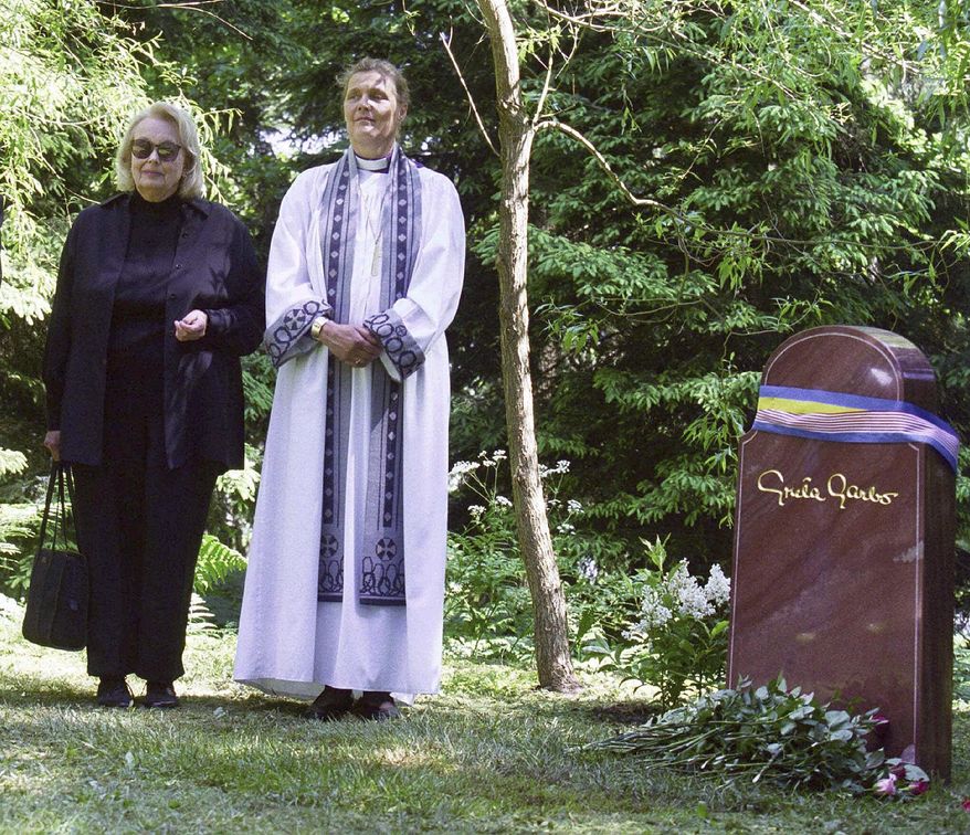 FILE - In this June 17, 1999 file photo, Gray Gustafson Reisfield, left, and Bishop Caroline Krook stand next to the tombstone of Greta Garbo after the memorial service at the Woodland Cemetery in Stockholm, Sweden. Reisfield, the sole heiress to her aunt Greta Garbo&#39;s estate and a woman who was a long-time companion to the late Swedish-born actress, has died, a family member said Monday, July 10, 2017. (Tobias Rostlund/TT via AP, File)