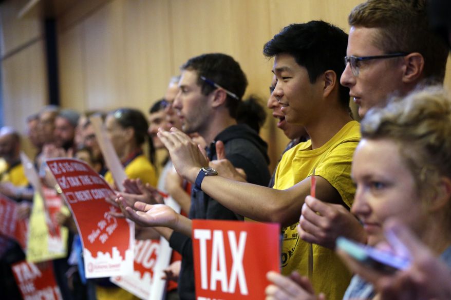 Audience members applaud as they look on during public comments at a Seattle City Council meeting where a new city income tax on the wealthy was being considered Monday, July 10, 2017, in Seattle. Seattle&#39;s highest earners would become the only Washington state residents to pay an income tax under the proposal that is designed to open a broader discussion about whether the wealthy pay their fair share in this booming city. (AP Photo/Elaine Thompson)