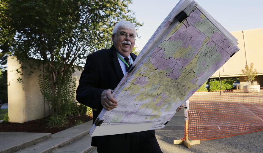 A man with a set of maps makes his way to the federal court house, Monday, July 10, 2017, in San Antonio, where a redistricting trial is set to begin. Federal courts earlier this year found that Texas passed election laws to purposefully discriminate against Hispanic and black voters and the trial starting Monday could redraw Texas voting maps before 2018 and bolster Democratic efforts to reclaim Congress. (AP Photo/Eric Gay)
