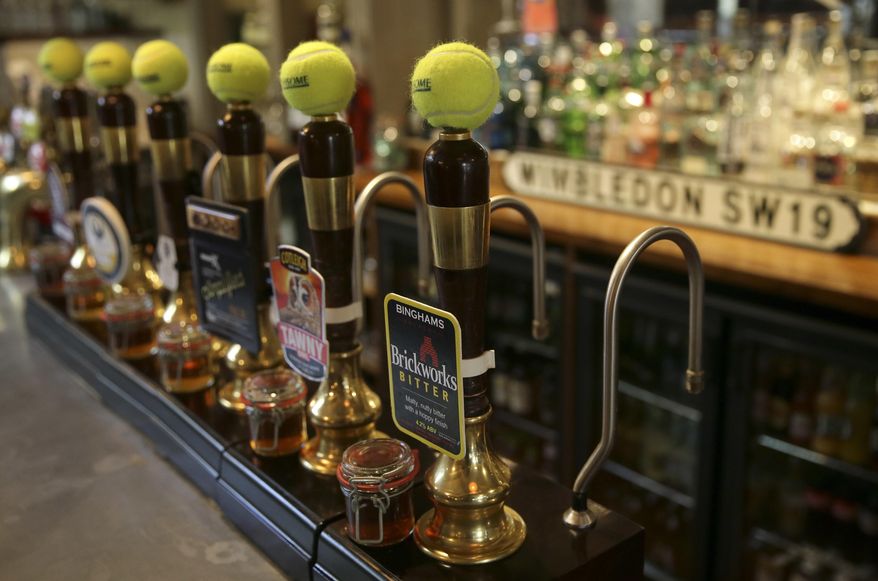 Tennis balls adorn the tops of the beer pumps inside the Hand & Racket pub in Wimbledon within walking distance of the All England Club during the Wimbledon Tennis Championships in London Monday, July 10, 2017. The presentation is one of several dozen on display throughout the village, which created a competition for businesses three years ago. (AP Photo/Tim Ireland)
