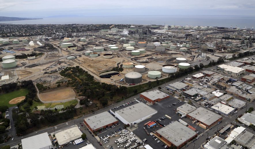 FILE - This May 25, 2017 file photo shows the Standard Oil Refinery in El Segundo, Calif., on the Pacific Ocean. A plan to extend California's cap-and-trade program for another decade looks beyond cutting greenhouse gas emissions and takes aim at toxic air in the polluted neighborhoods around refineries and factories. (AP Photo/Reed Saxon, File)
