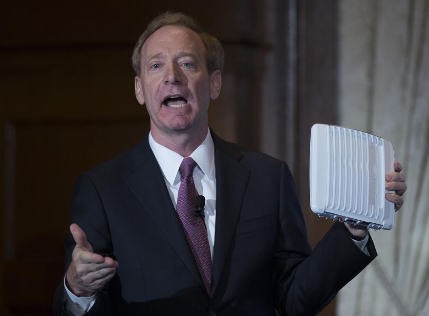 Microsoft President and Chief Legal Officer Brad Smith holds up an ACRS2 device by ADAPTRUM used in TV White Space communications as he speaks in Washington, Tuesday, July 11, 2017, about Microsoft&#39;s project to bring broadband internet access to rural parts of the U.S. (AP Photo/Carolyn Kaster)