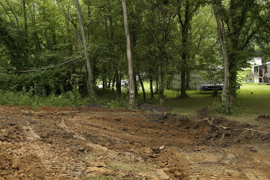 The FBI and local law enforcement searched a property located in Union Township north of Chesapeake, W.V., on Tuesday, July 11, 2017. The search began after officials responded to Facebook posts that the body of Marshall University student Samantha Burns, a 2002 murder victim whose body has never been found, was buried behind a mobile home along Township Road 1465. (Sholten Singer/The Herald-Dispatch via AP)
