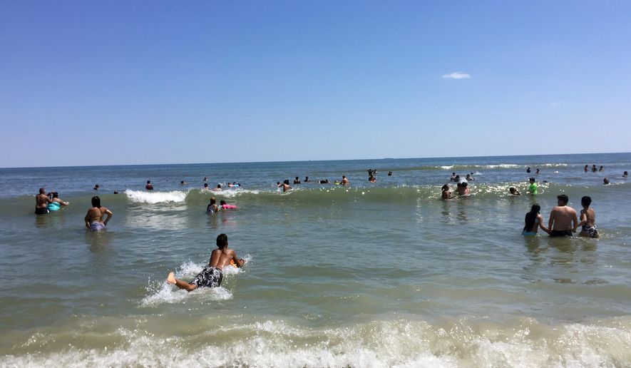 This July 9, 2017 photo shows a beach in the Rockaways, in the Queens borough of New York, on the Atlantic Ocean, with some beach-goers using body boards to ride the waves. A new ferry that travels between Lower Manhattan and the Rockaways has made it easier to get to the beach, which is known for its crashing surf. (AP Photo/Beth J. Harpaz)