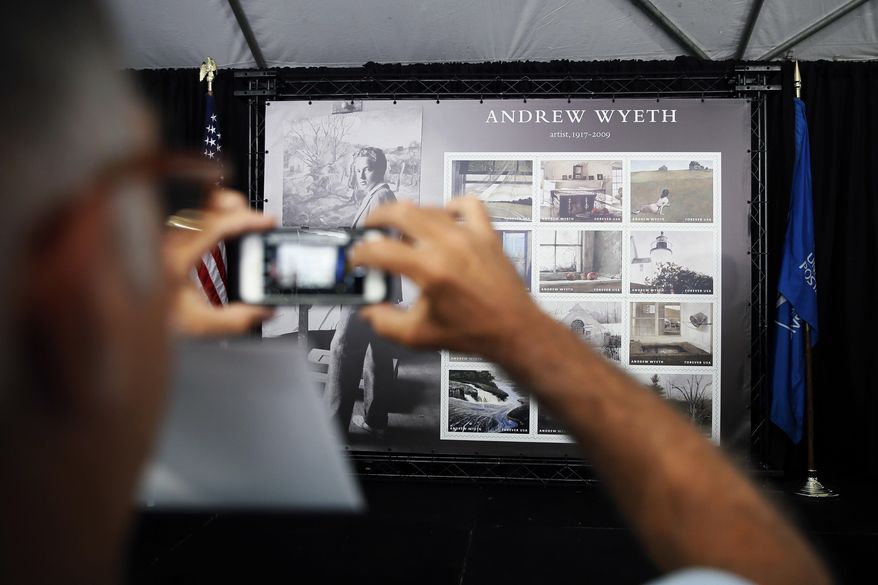 A man takes a photograph of a display of Andrew Wyeth Forever stamps after a First-Day-of-Issue dedication ceremony at the Brandywine River Museum of Art, Wednesday, July 12, 2017, in Chadds Ford, Pa. The panel of 12 Forever stamps feature details from different iconic Andrew Wyeth paintings. (AP Photo/Matt Slocum)