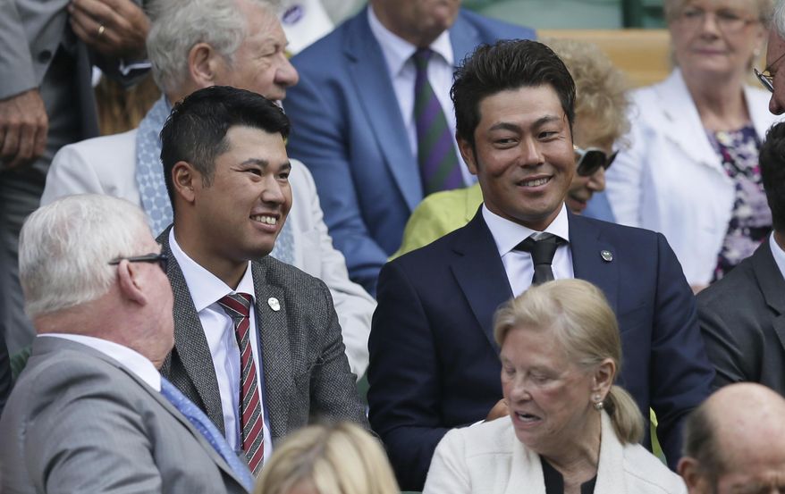 Japanese golfers Hideki Matsuyama, left, and Hideto Tanihara, right, take their seats on Centre Court on day nine at the Wimbledon Tennis Championships in London, Wednesday, July 12, 2017. (AP Photo/Tim Ireland)
